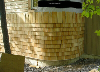 Photo of a circular wall in cedar shingles.